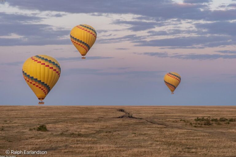 Hot air balloons flying over San Miguel de Allende at sunrise with colonial city and mountains below
